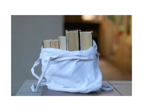 Books in a white tote bag