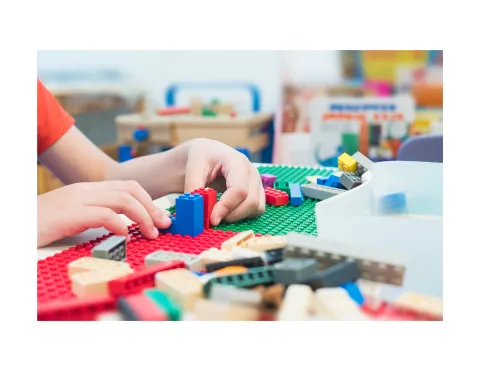 Child building with LEGO.
