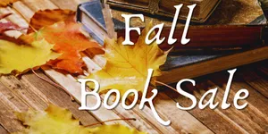 "Fall book sale" hovers over fall leaves and old books