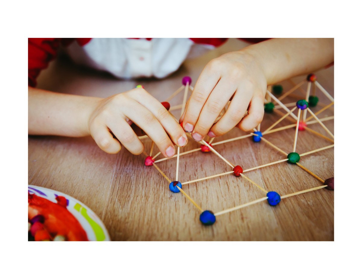 Child building with toothpick and playdough.